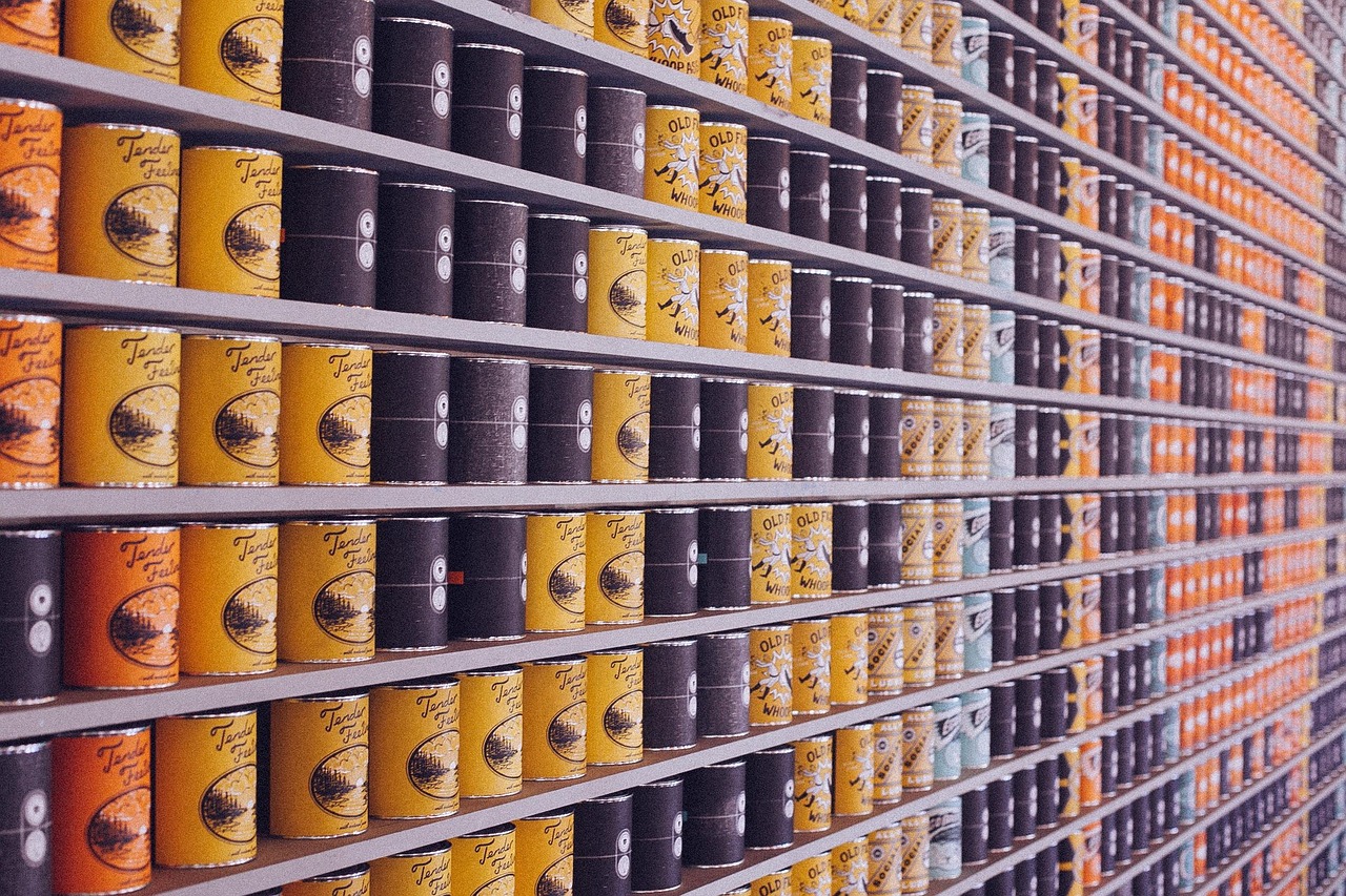 Stack of food-grade containers and disposable cutlery in an organized warehouse setting